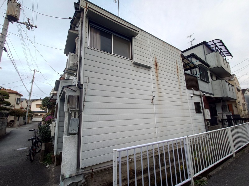 兵庫県尼崎市上ノ島町の空き家の外観。水路沿いに建つ2階建て木造住宅の側面