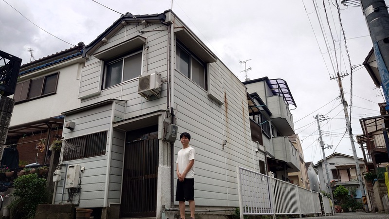 兵庫県尼崎市上ノ島町の空き家外観。2階建て木造住宅の前に立つひぐちさん