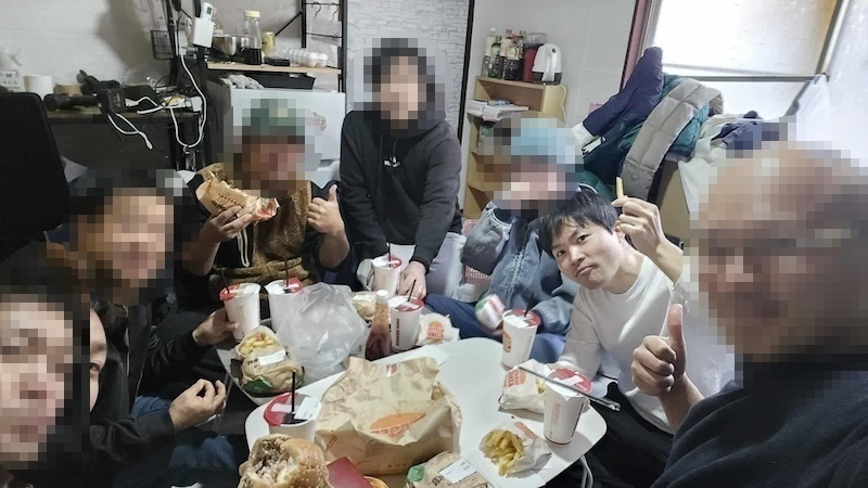 東京都江戸川区の放置された空き家アパートの掃除が終わって食事中の参加者達