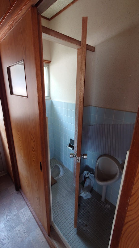 空き家を管理、水色タイルのトイレ入口