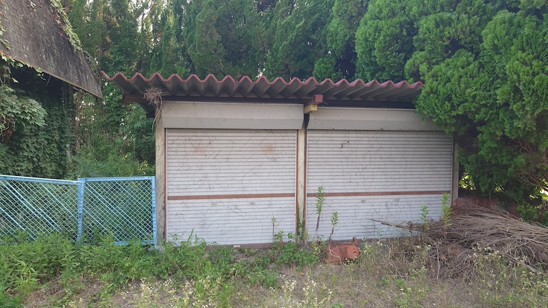 兵庫県加東市小沢の空き家の、シャッター付きの物置小屋