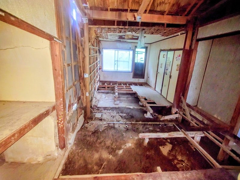 大阪府枚方市渚栄町の空き家の玄関から見た室内、床が抜けて地面が見えている状態